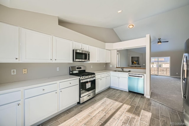 kitchen with white cabinetry, ceiling fan, stainless steel appliances, and vaulted ceiling