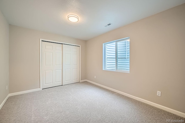 unfurnished bedroom with a closet and carpet