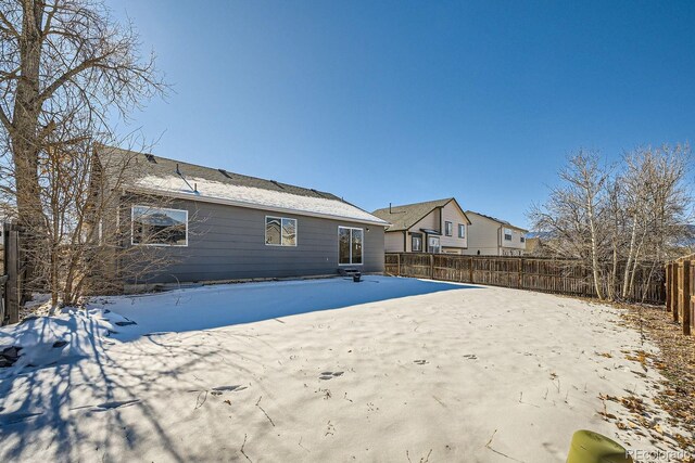 view of snow covered rear of property