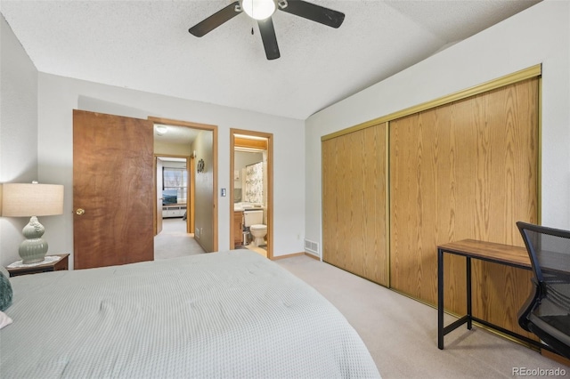 bedroom with light carpet, visible vents, a ceiling fan, connected bathroom, and a textured ceiling