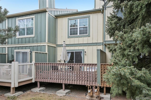 back of property featuring board and batten siding and a wooden deck