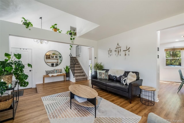 living room featuring wood-type flooring and an inviting chandelier