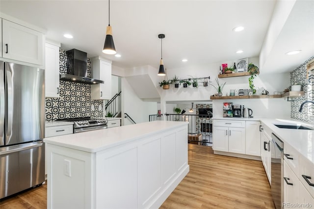 kitchen featuring white cabinets, light hardwood / wood-style flooring, sink, decorative light fixtures, and stainless steel appliances