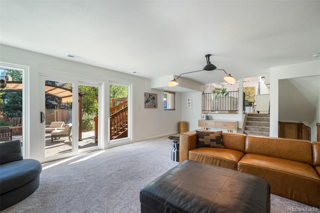 carpeted living room featuring a textured ceiling and plenty of natural light