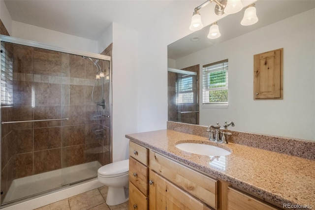 bathroom with vanity, toilet, tile patterned flooring, and an enclosed shower