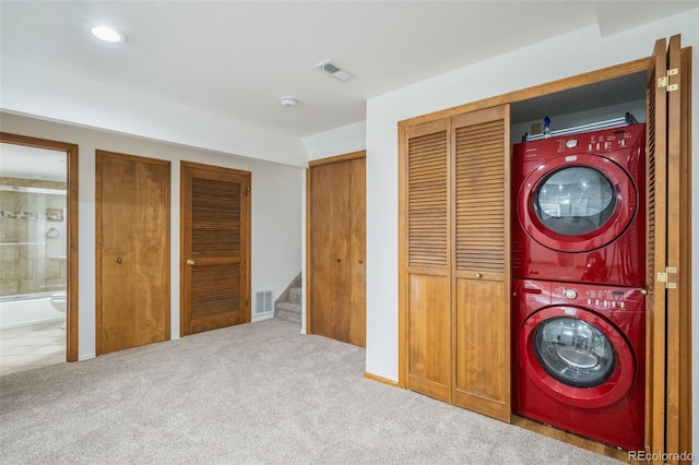 clothes washing area featuring light colored carpet and stacked washing maching and dryer