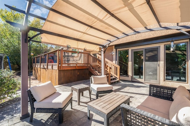 view of patio / terrace featuring a wooden deck, an outdoor living space, and a pergola