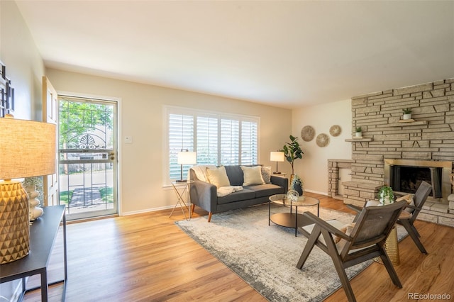 2744 S Newton Way, Denver, CO 80236 - living area featuring light wood-type flooring, a stone fireplace, and baseboards