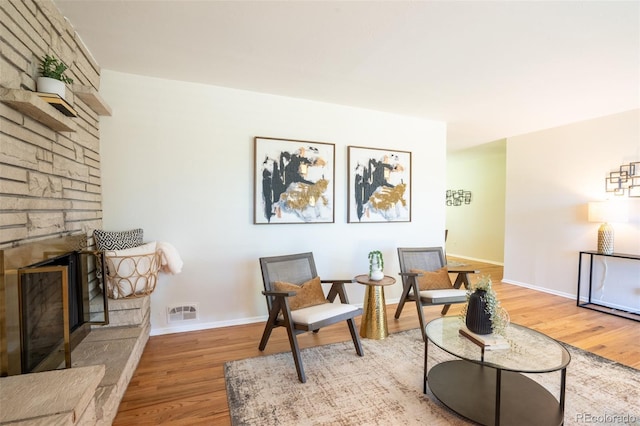 2744 S Newton Way, Denver, CO 80236 - sitting room featuring wood finished floors, a stone fireplace, and baseboards