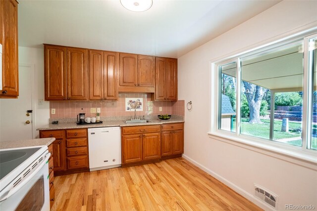 2744 S Newton Way, Denver, CO 80236 - kitchen with white appliances, light wood-style flooring, brown cabinetry, and decorative backsplash