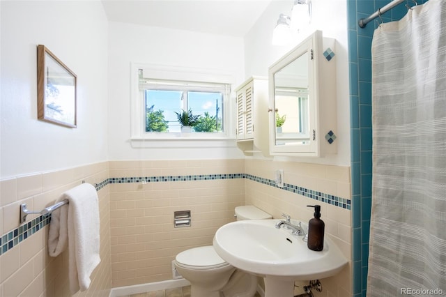 2744 S Newton Way, Denver, CO 80236 - bathroom featuring tile walls, toilet, curtained shower, a sink, and wainscoting