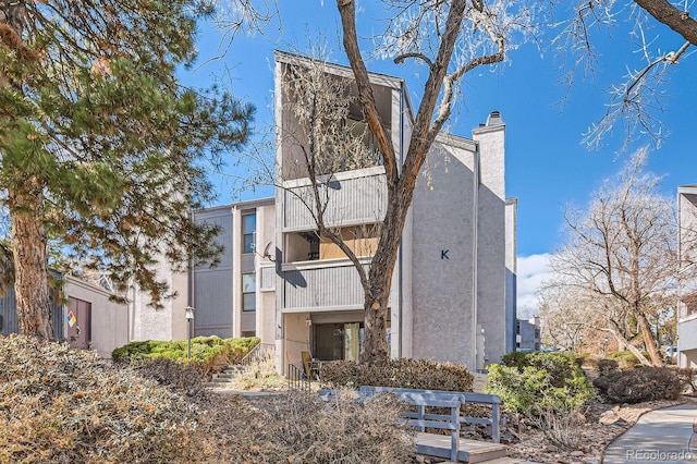 view of property exterior featuring a chimney and stucco siding