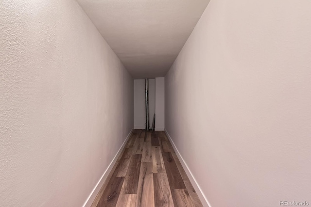 hall featuring baseboards and wood finished floors