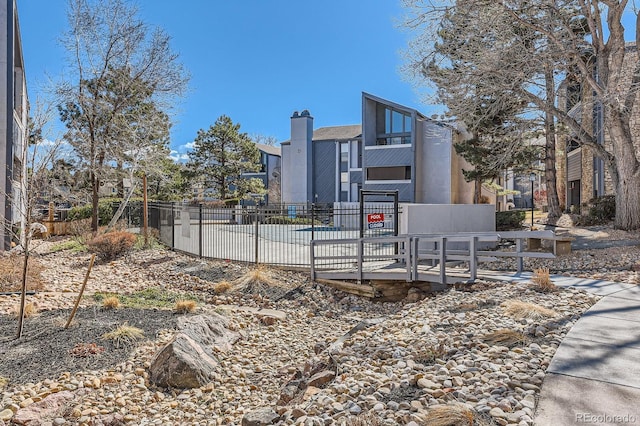 view of home's community featuring fence