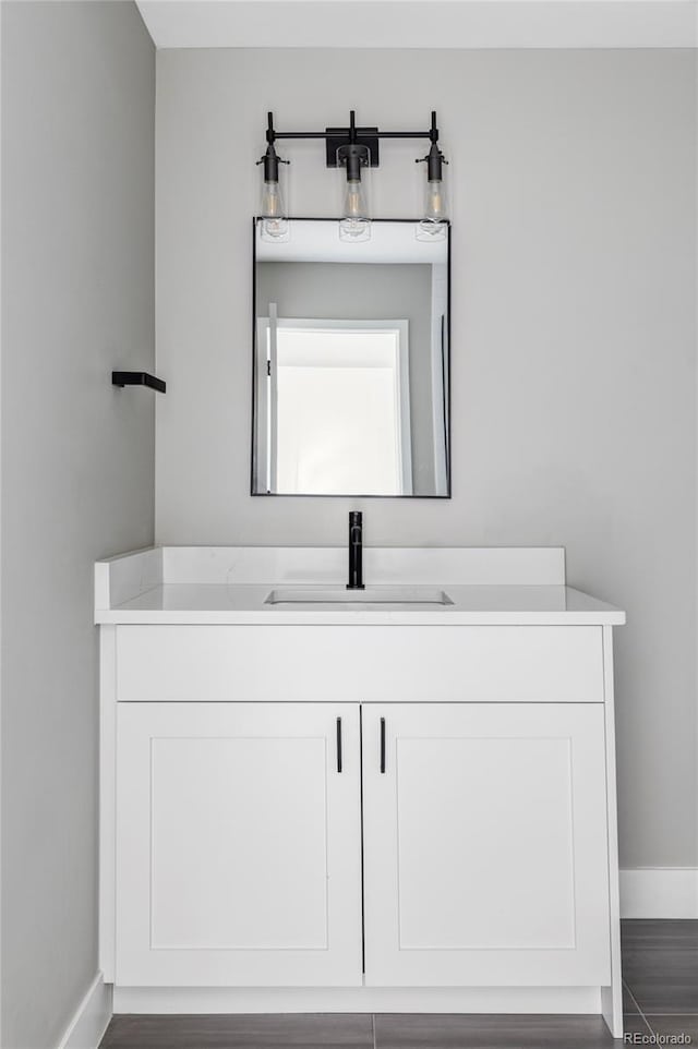 1543 Glencoe St, Denver, CO 80220 - bathroom with baseboards, vanity, and wood finished floors