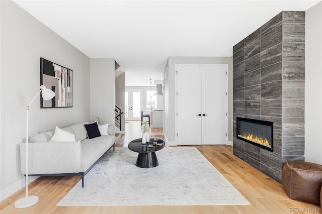 1543 Glencoe St, Denver, CO 80220 - living area featuring wood finished floors, a tiled fireplace, stairway, and baseboards
