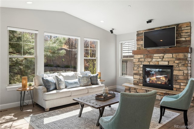6877 Northstar Ct, Castle Rock, CO 80108 - living area with healthy amount of natural light, lofted ceiling, wood finished floors, and a stone fireplace