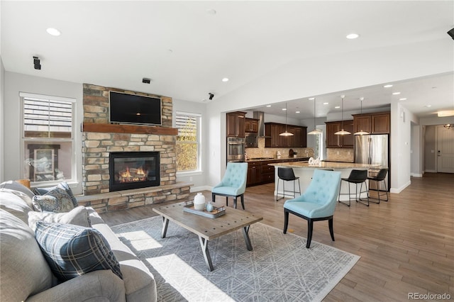 6877 Northstar Ct, Castle Rock, CO 80108 - living area featuring vaulted ceiling, a fireplace, light wood-style floors, and recessed lighting