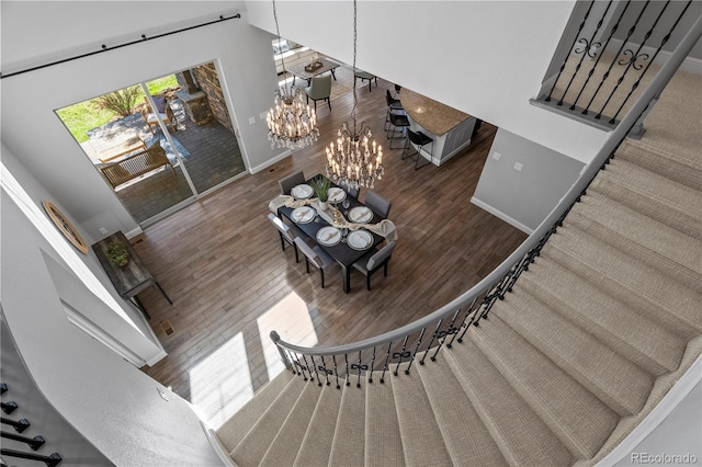 6877 Northstar Ct, Castle Rock, CO 80108 - stairway featuring a chandelier, wood finished floors, and a towering ceiling
