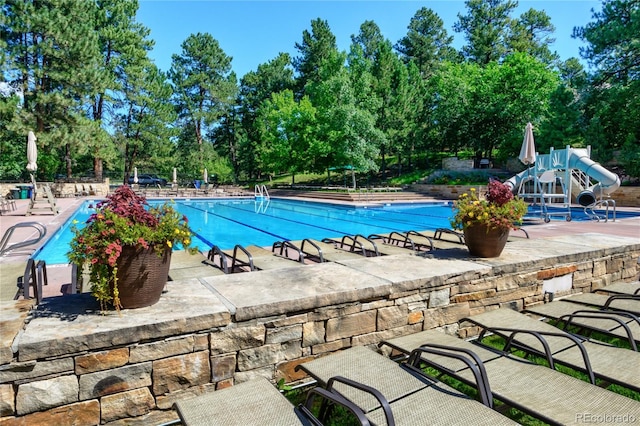 6877 Northstar Ct, Castle Rock, CO 80108 - community pool featuring view of wooded area, a patio, and a water slide