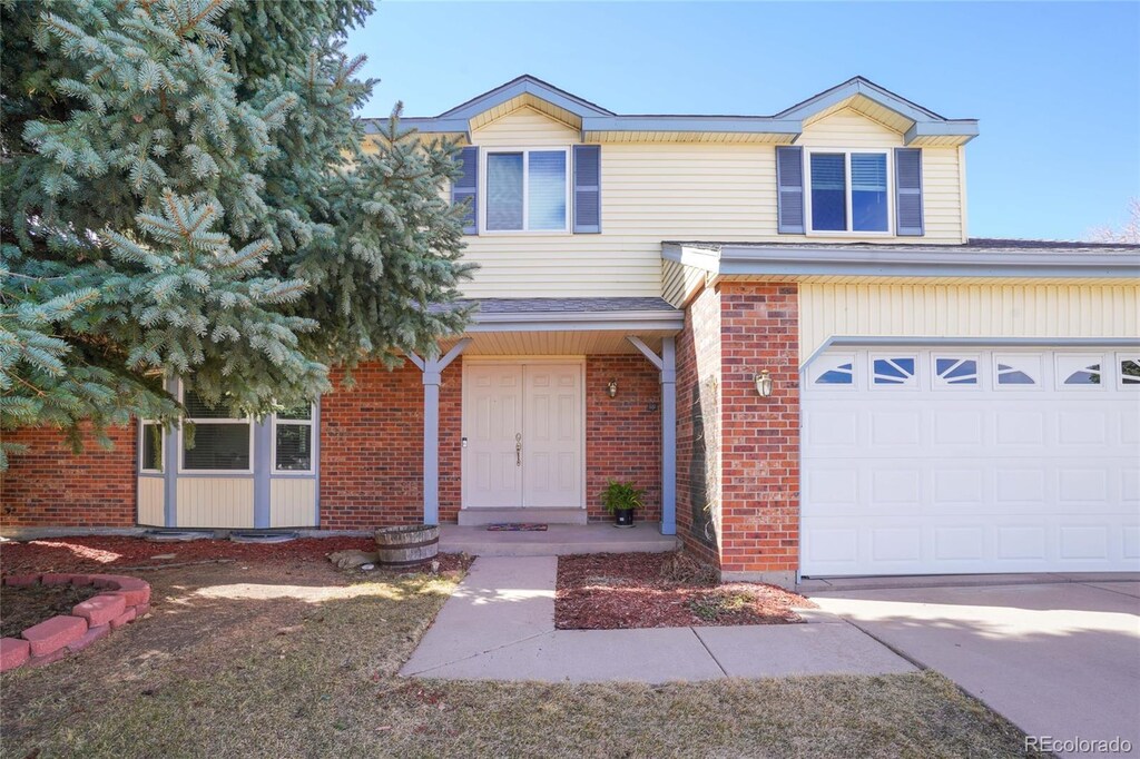 view of front of home featuring a garage and brick siding