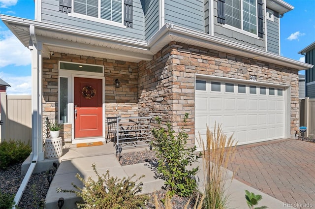 property entrance featuring a garage and stone siding