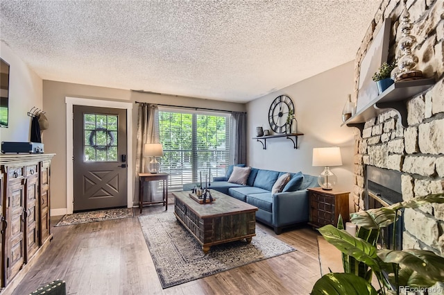 8252 S Fillmore Cir, Centennial, CO 80122 - living room with a textured ceiling, a fireplace, and light wood-style flooring