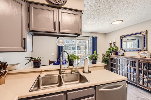 8252 S Fillmore Cir, Centennial, CO 80122 - kitchen featuring stainless steel dishwasher, light countertops, a textured ceiling, and light wood-type flooring