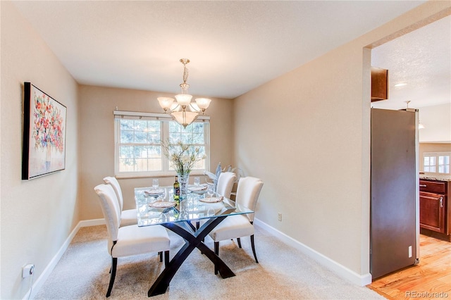 dining area featuring an inviting chandelier, baseboards, and plenty of natural light