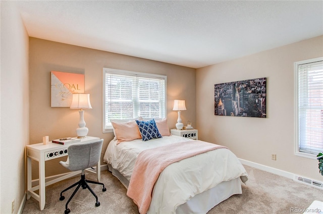 carpeted bedroom featuring baseboards, multiple windows, and visible vents