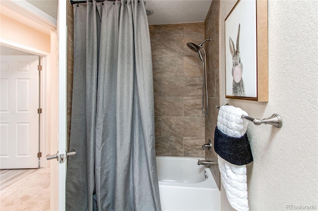 full bath featuring a textured wall and shower / bath combo