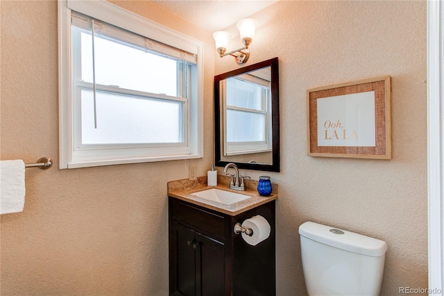 half bath featuring vanity and toilet