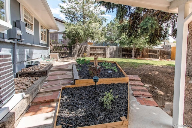 view of yard with fence, central AC, and a vegetable garden