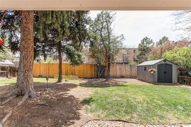 view of yard featuring an outdoor structure, a shed, and a fenced backyard
