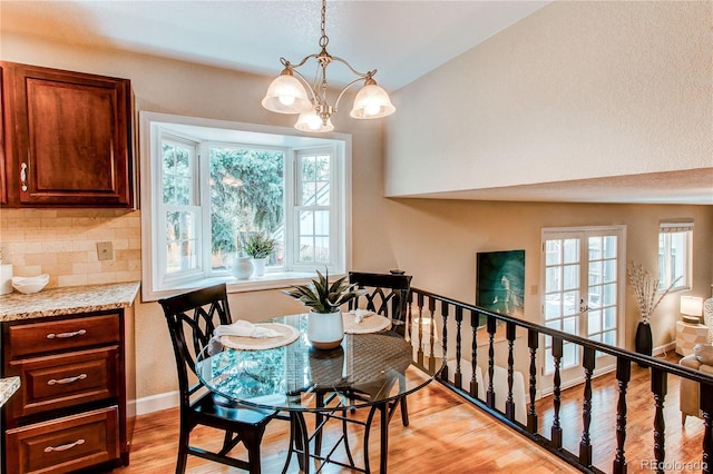 dining room with light wood-style floors, baseboards, and a notable chandelier