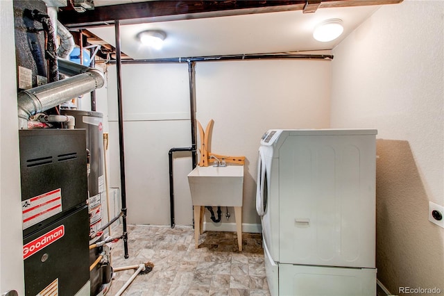 clothes washing area featuring a sink, laundry area, and washing machine and clothes dryer