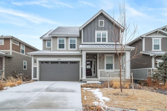 view of front of house featuring a porch, board and batten siding, a standing seam roof, a garage, and driveway