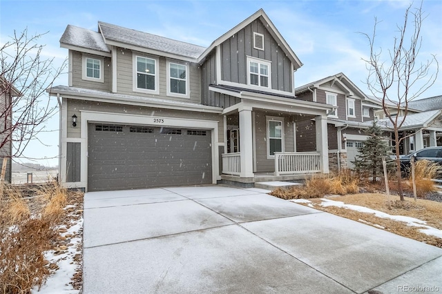 view of front of property featuring covered porch, driveway, board and batten siding, and a garage