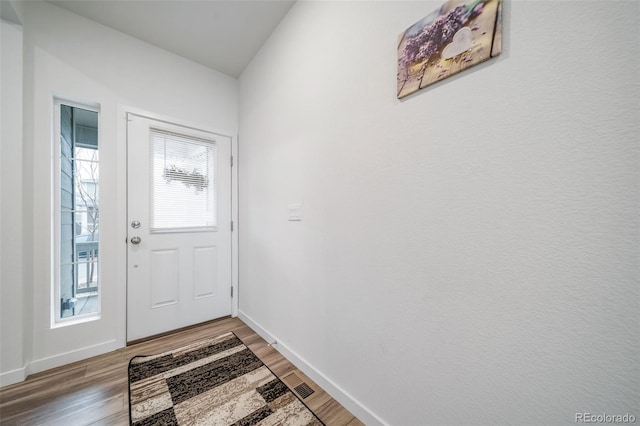 doorway with baseboards and light wood finished floors