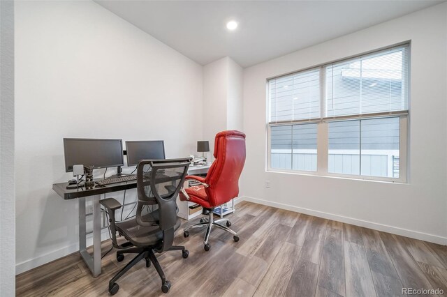 home office with baseboards and wood finished floors