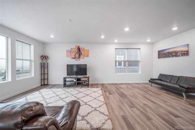 living area with light wood-type flooring, baseboards, and recessed lighting