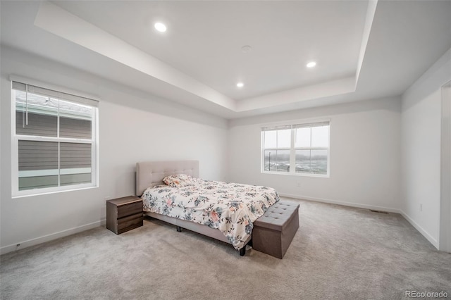 bedroom featuring a tray ceiling, carpet flooring, and baseboards