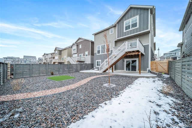 back of house with a patio, a fenced backyard, a residential view, stairway, and board and batten siding