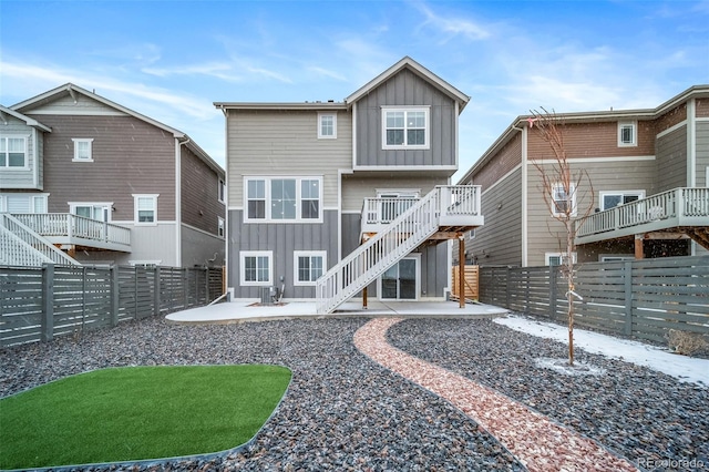 back of property featuring a fenced backyard, board and batten siding, and a patio