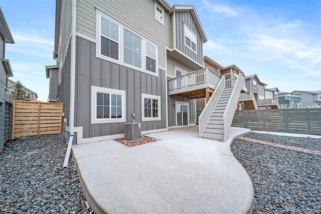 exterior space featuring fence private yard, stairway, and board and batten siding