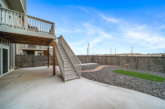 view of patio with stairway and a fenced backyard