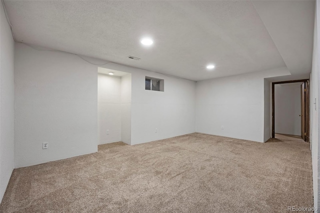 empty room with a textured ceiling and carpet flooring