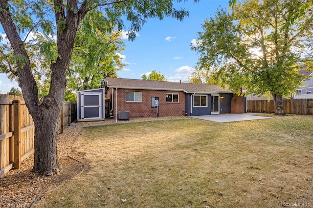 back of house with central air condition unit, a patio area, and a yard