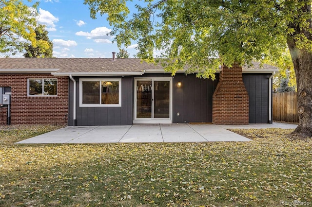 rear view of property featuring a patio and a lawn