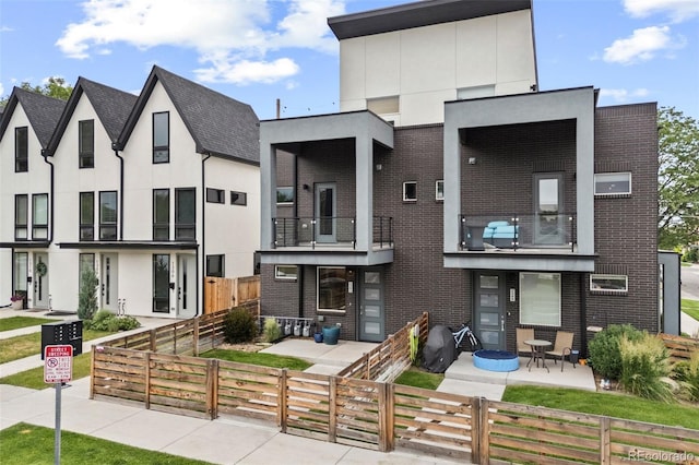 1302 N Stuart St, Denver, CO 80204 - contemporary house featuring a fenced front yard, brick siding, and stucco siding